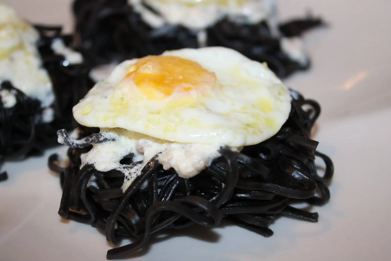 NIDOS DE ESPAGUETIS EN SU TINTA CON CREMA DE QUESO