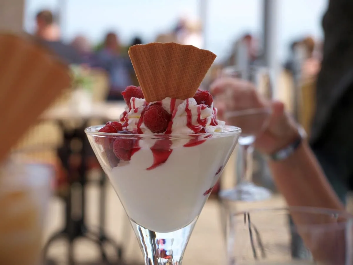 Postre helado de yogur con sirope de fresas
